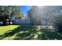 Charming single-story home featuring a lush green lawn and mature trees, offering a serene and inviting curb appeal at 5200 Brosche Rd, Orlando, FL 32807