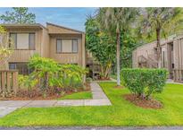 Inviting condo featuring a quaint walkway, lush landscaping, and a charming wood facade at 5337 Indian Creek Dr # C-4-1, Orlando, FL 32811