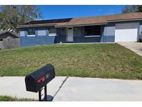 Charming single-story home with a well-maintained lawn and solar panels at 7813 Arabian Pl, Orlando, FL 32818