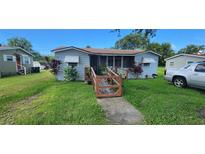 Charming single-story home featuring a ramp, screened porch, and mature landscaping at 838 Bethune Ave, Winter Garden, FL 34787