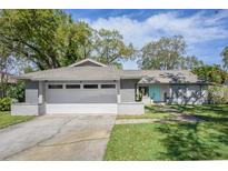 Charming single-story home with a gray exterior, well-manicured lawn, and a two-car garage at 1685 Colleen Dr, Belle Isle, FL 32809