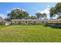 Charming single-story home with a well-manicured lawn and mature trees providing shade at 215 Forrest Dr, Sanford, FL 32773