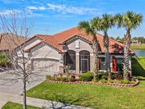 Charming home featuring lush landscaping, a barrel tile roof and bright red shutters at 2541 Shoal Bass Way, Kissimmee, FL 34746