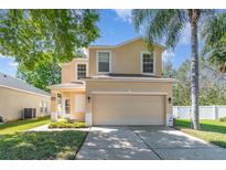 Inviting two-story home featuring a spacious two-car garage and well-maintained lawn with mature trees at 322 Lusitano Way, Sanford, FL 32773