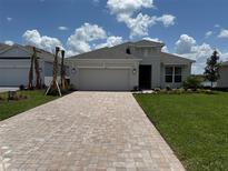 Charming single-Gathering home features a paved driveway, manicured lawn, and a neutral color palette at 4203 Barbuda Ln, Kissimmee, FL 34758