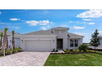 Beautiful single-story home featuring manicured lawn, brick driveway, and an attached two-car garage at 4203 Barbuda Ln, Kissimmee, FL 34758