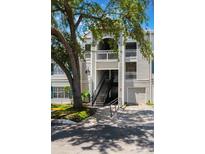 Exterior view of a condo with garages, staircases, and balconies, set against a blue sky at 5144 City St # 238, Orlando, FL 32839