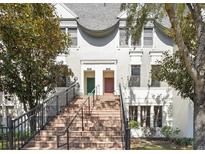 Inviting two-story townhouse with a brick staircase leading to dual front doors and ample natural lighting at 556 Copley Ln, Orlando, FL 32806