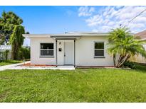 Charming single-story home with a well-manicured lawn and freshly painted white exterior at 859 Neuse Ave, Orlando, FL 32804