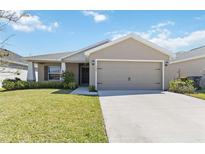 Charming one-story home featuring a well-manicured lawn, attached two-car garage, and inviting front entrance at 1575 Eucalyptus Way, Davenport, FL 33837
