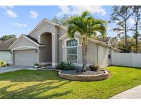 Charming single-story home featuring a well-manicured lawn, inviting curb appeal, and a quaint palm tree accent at 26 Pied Ct, Orlando, FL 32828