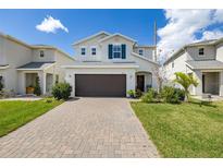 Charming two-story home featuring a brick driveway, well-manicured lawn, and a two-car garage at 2817 Noble Crow Dr, Kissimmee, FL 34744