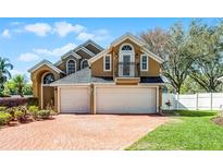 Charming two-story home with a three-car garage and brick-paved driveway at 352 Misty Oaks Run, Casselberry, FL 32707