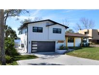 Stunning two-story home featuring modern design, gray garage door, and lush landscaping at 382 Riverside Dr, Ormond Beach, FL 32176