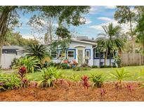 Charming single story home featuring mature landscaping, lawn, and palms at 430 E Crystal Lake St, Orlando, FL 32806