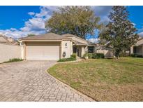 Charming single-Gathering home featuring a brick driveway, two-car garage, and well-manicured lawn at 545 Ne 45Th Ct, Ocala, FL 34470