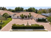 Beautiful home with red brick driveway, well-manicured landscaping, and a charming water fountain at 5950 Masters Blvd, Orlando, FL 32819
