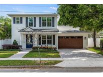 Charming two-story home with a well-manicured lawn, brick pathway, and a two car garage at 900 Golfview St, Orlando, FL 32804