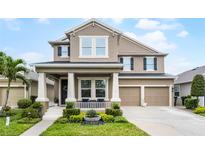 Charming two-story home with landscaped yard and a two-car garage under a bright blue sky at 10078 Greenshire Way, Orlando, FL 32827