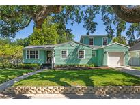 Charming two-story home featuring a well-maintained lawn, stone accents, and beautiful mature trees offering shade at 1111 Guernsey St, Orlando, FL 32804
