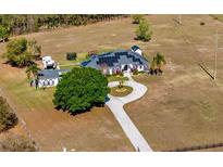 Expansive property with a custom home featuring solar panels and a circular driveway at 17117 Heartwood Loop, Winter Garden, FL 34787