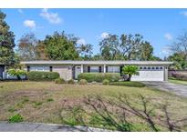 Charming single story home featuring a manicured lawn and mature landscaping at 2019 Loch Berry Rd, Winter Park, FL 32792