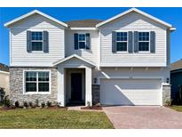 Charming two-story home featuring stone accents, a two-car garage, and a well-maintained lawn at 2036 Iorio Dr, St Cloud, FL 34771