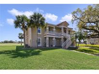 Inviting two-story home with a beautifully landscaped lawn, mature trees, and private stairwell leading to the 2nd story at 2808 Osprey Cove Pl # 202, Kissimmee, FL 34746