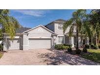 Charming two-story home with manicured landscaping, paver driveway, and attached two car garage at 5006 Legacy Oaks Dr, Orlando, FL 32839