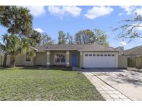 Charming single-story home with well-maintained lawn, blue front door, and attached two-car garage at 5317 Montford Pl, Apopka, FL 32712