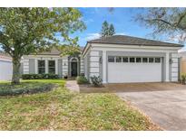 Charming single-story home with lush landscaping, a two-car garage, and a welcoming entrance at 6058 Jamestown Park, Orlando, FL 32819