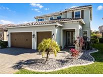 Beautiful two-story home featuring a tile roof, manicured landscaping, and a two-car garage at 10454 Siddington Dr, Orlando, FL 32832
