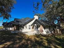 Charming home featuring brick accents, solar panels, and a spacious patio area perfect for outdoor entertaining at 1102 Hamlin Ave, Howey In The Hills, FL 34737