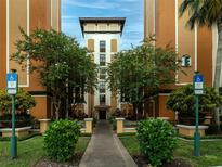 Inviting building entrance with manicured landscaping and accessible parking at 12527 Floridays Resort Dr # 401E, Orlando, FL 32821