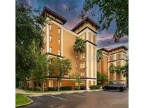 Beautiful exterior shot of a condo building featuring manicured landscaping and a parking lot at 12527 Floridays Resort Dr # 401E, Orlando, FL 32821