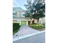 Charming townhouse with a well-manicured front yard and brick-paved driveway at 1828 Lemon Drop Ct, Apopka, FL 32712