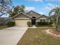 Charming single-story home featuring a well-maintained lawn, mature trees, and an attached two-car garage at 332 Lake Doe Blvd, Apopka, FL 32703