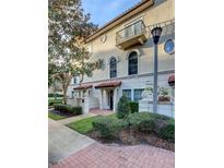 Charming two-story townhome with a balcony, red tiled roof, arched windows, and lush landscaping at 4624 Messina Dr, Lake Mary, FL 32746