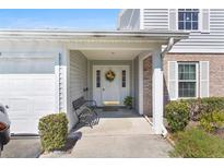 Inviting front entrance with a charming floral wreath, bench, and covered porch at 5273 Tunbridge Wells Ln # 1601, Orlando, FL 32812
