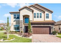 Stunning two-story home featuring a terra cotta roof, stone accents and a brick paver driveway at 612 Via Isabelle Dr, Debary, FL 32713