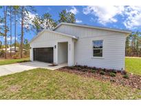 Charming single-story home featuring a modern design, attached garage, and fresh landscaping at 7117 Sw 131St Ave, Ocala, FL 34481
