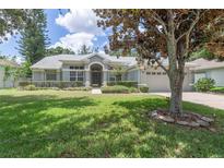 Charming one-story home featuring a well-manicured lawn, mature landscaping, and a welcoming entrance at 7506 Lindenhurst Dr, Orlando, FL 32836