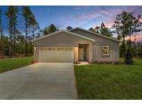 Charming single-story home featuring a two-car garage, neutral paint scheme, and well-manicured lawn at 8459 Sw 138Th Ter, Dunnellon, FL 34432