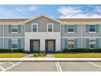 Charming two-story townhomes with gray siding and blue shutters offering a welcoming curb appeal at 926 Paradise Dr, Davenport, FL 33897