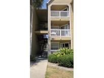 Exterior view of the three-story condo building with access stairwells and lush landscaping at 1083 S Hiawassee Rd # 635, Orlando, FL 32835