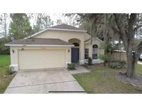 Charming single-story home featuring a two-car garage and well-maintained front yard at 13440 Fordwell Dr, Orlando, FL 32828