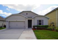 Charming single-story home featuring a two-car garage, well-manicured lawn, and neutral stucco exterior at 1588 Diamond Loop Dr, Kissimmee, FL 34744