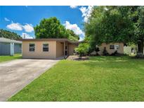 Charming single-story home with a well-maintained lawn and a classic, neutral-toned exterior at 1725 Marcia Dr, Orlando, FL 32807