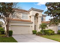 Beautiful two-story home displaying lush landscaping, a barrel tile roof, and an attached two-car garage at 2508 Archfeld Blvd, Kissimmee, FL 34747