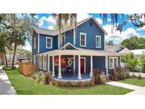 Charming two-story home with a blue facade, inviting front porch, and manicured lawn at 301 S Palmetto Ave, Sanford, FL 32771